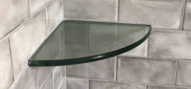 Glass shelf installed with shower tile work.
