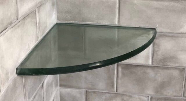 Glass shelf installed with shower tile work.