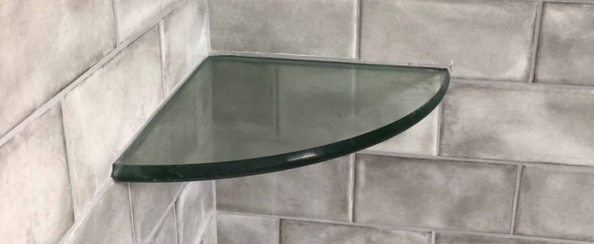 Glass shelf installed with shower tile work.